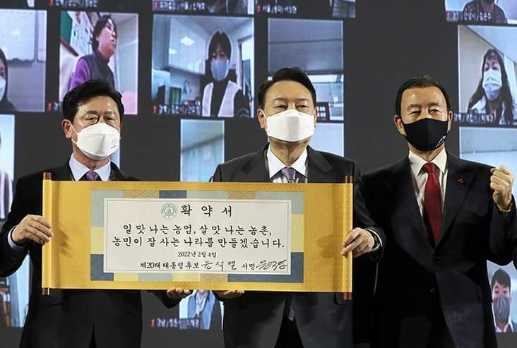 한국농업경영인중앙연합회가 지난 2월4일 주최한 ‘선택 2022! 대선후보 농정비전 발표회’에 참석한 윤석열 당선인(오른쪽)이 “일 맛 나는 농업, 살 맛 나는 농촌, 농민이 잘 사는 나라를 만들겠습니다”라는 문구가 쓰여진 확약서에 서명한 후 이학구 한농연중앙연합회, 홍문표 국회의원과 함께 기념촬영을 하고 있다.