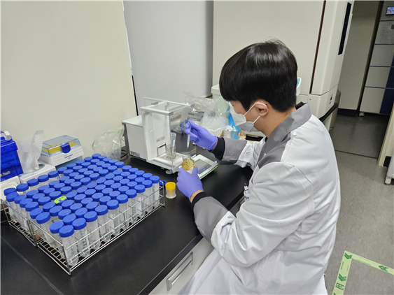 축산물품질평가사가 꿀을 분석하기 위해 전자저울에서 시료를 계량하고 있다